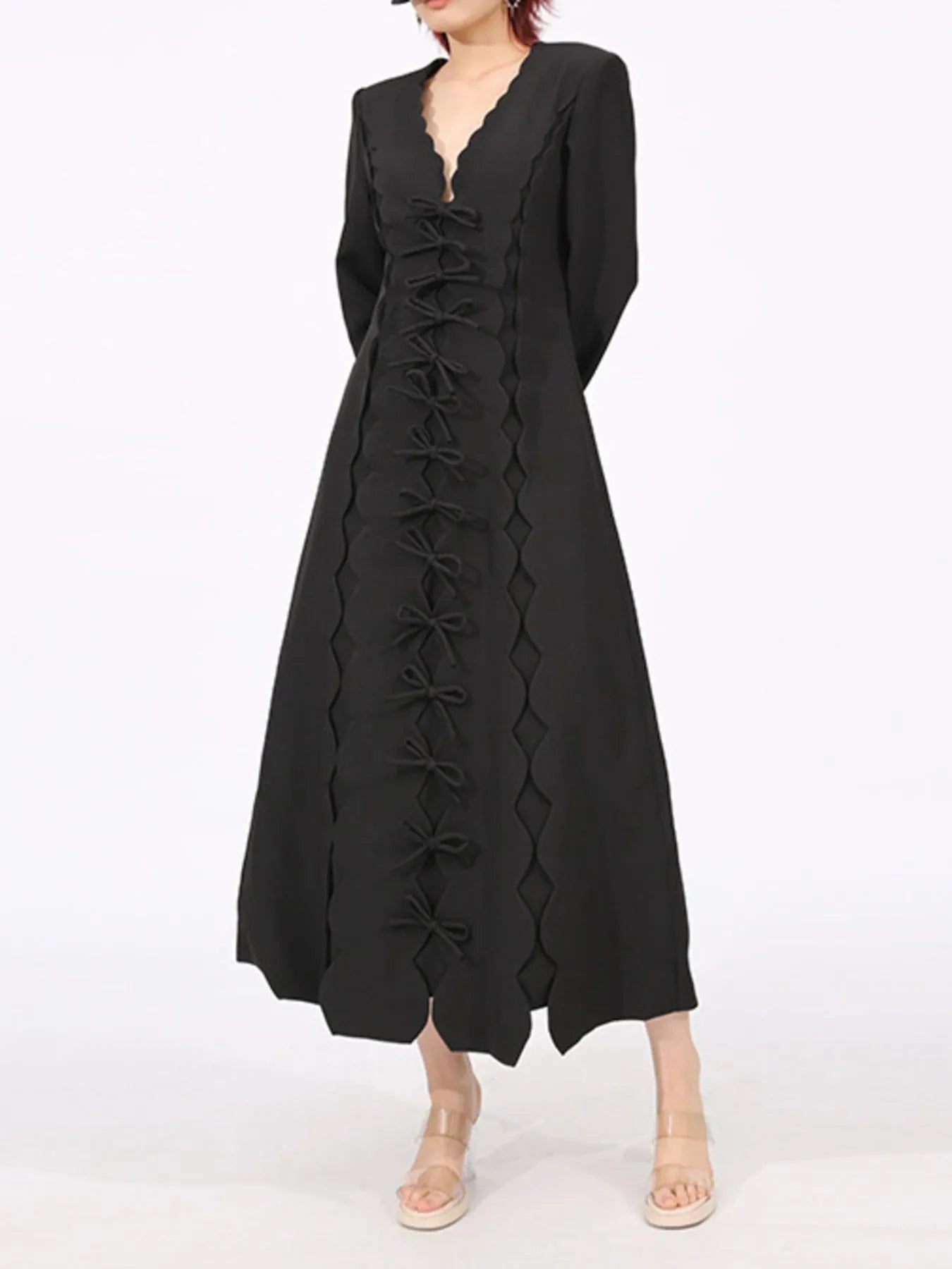 black long sleeve bow front midi dress with scalloped V neck and center bow tie detailing on model