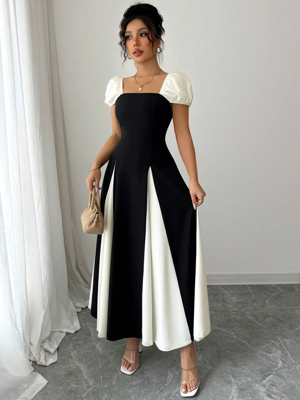 contrast puff sleeve midi dress black with white panels square neckline puff sleeves model holding beige bag