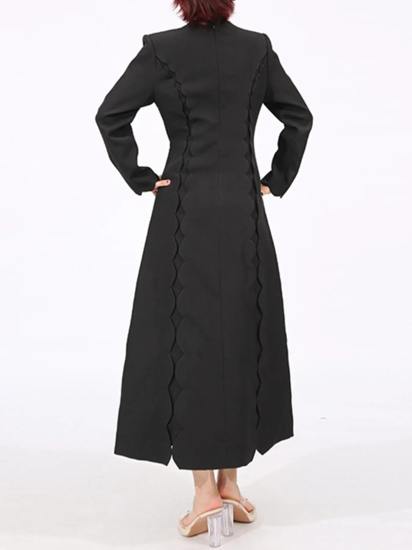 Back view of black long sleeve bow front midi dress with scalloped side seams fitted waist ankle length