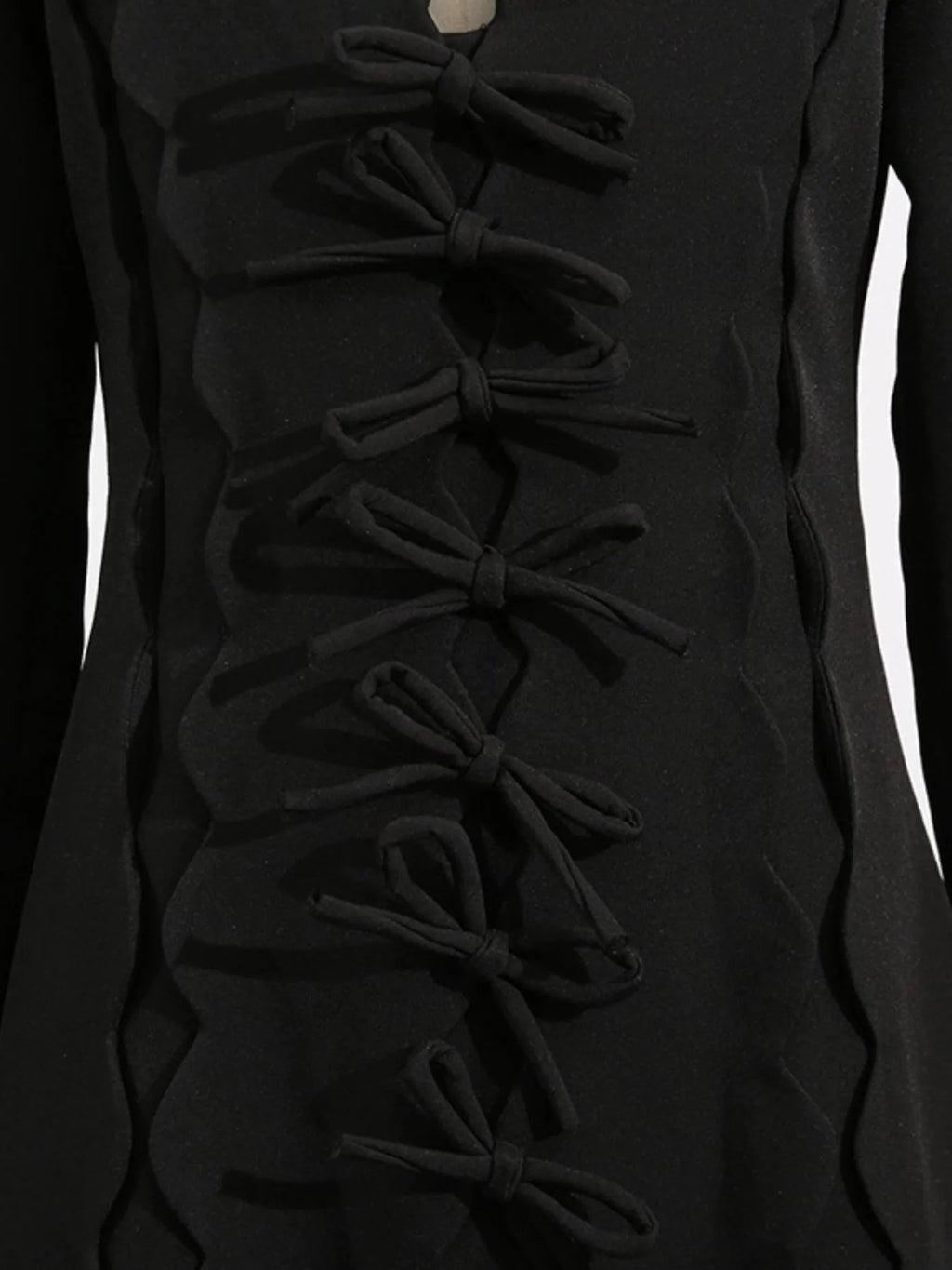black long sleeve bow front midi dress close up showing vertical tied bows and scalloped seams