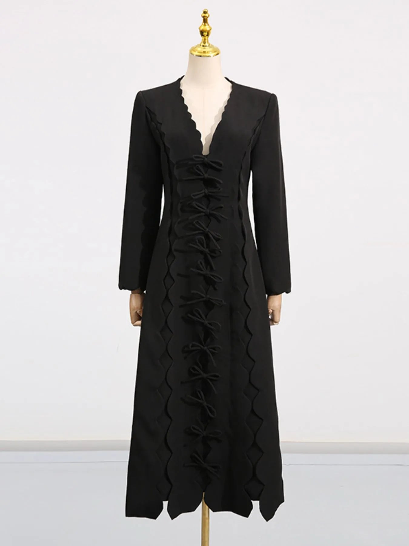 black V neck long sleeve bow front midi dress on mannequin with scalloped trim and center bow row