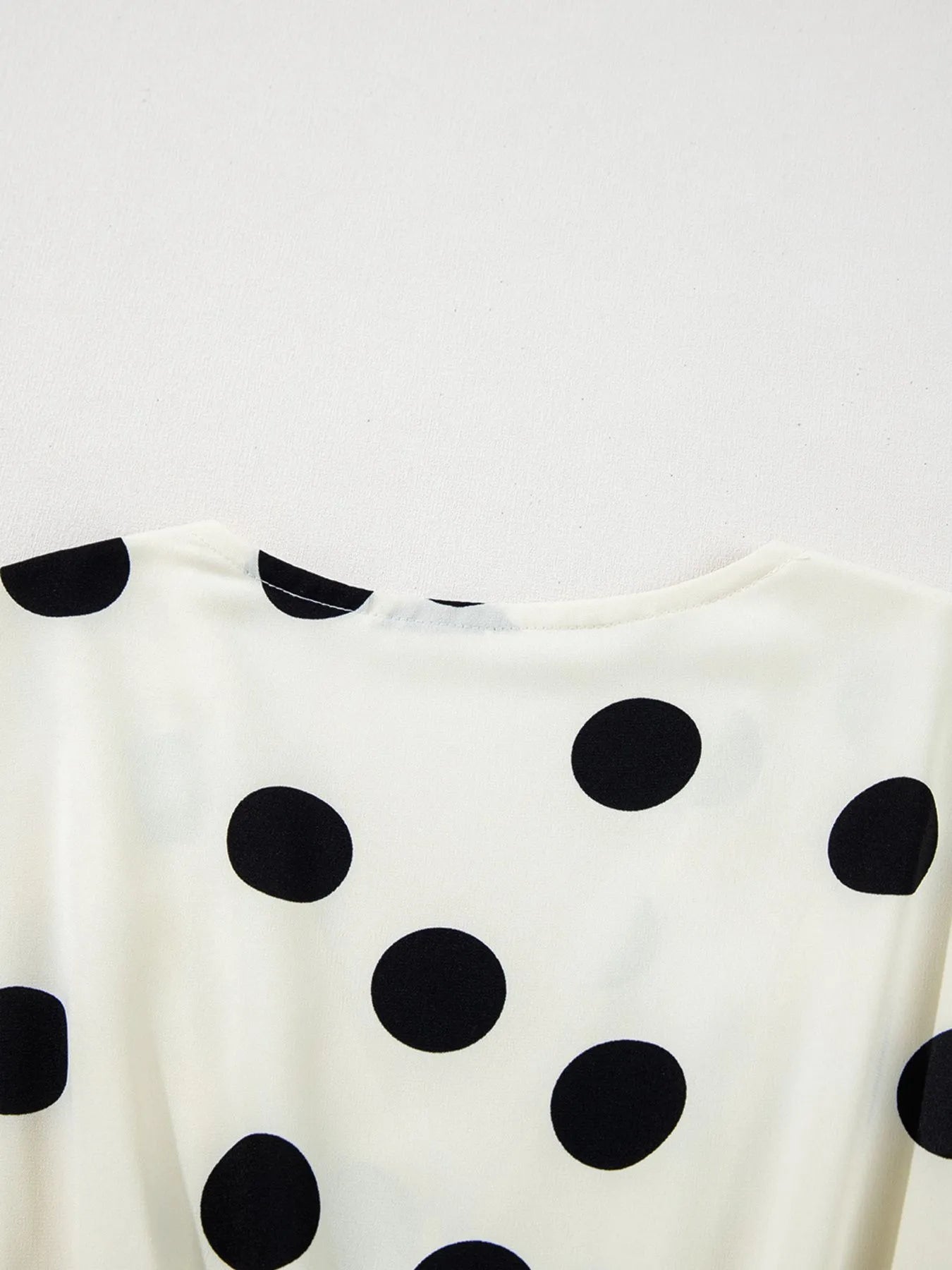 white and black polka dot mini dress back view with crew neckline and large dot pattern
