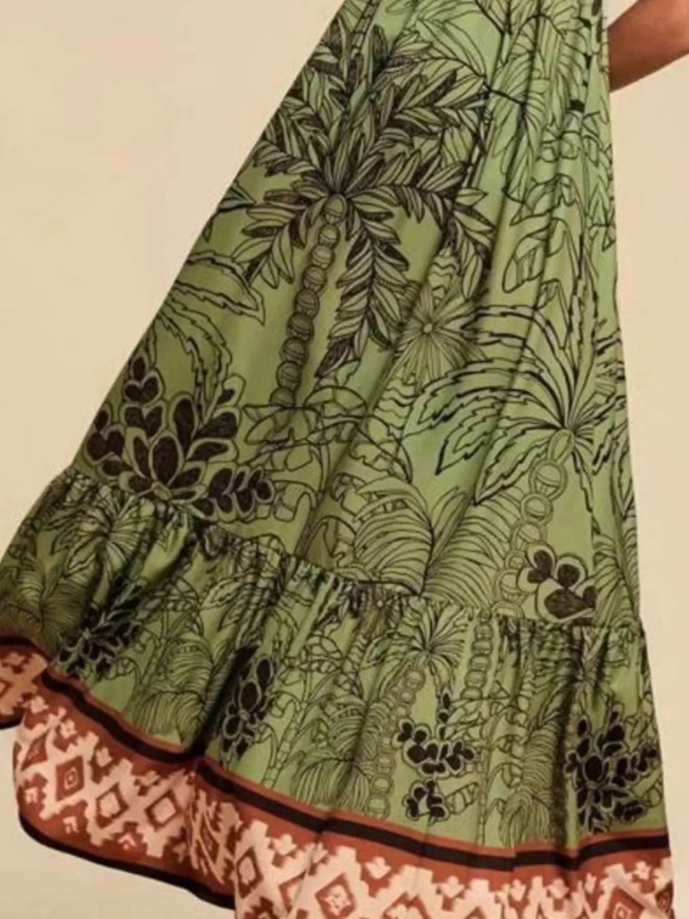 green tropical print maxi dress with black palm motifs and ruffle hem and brown patterned border