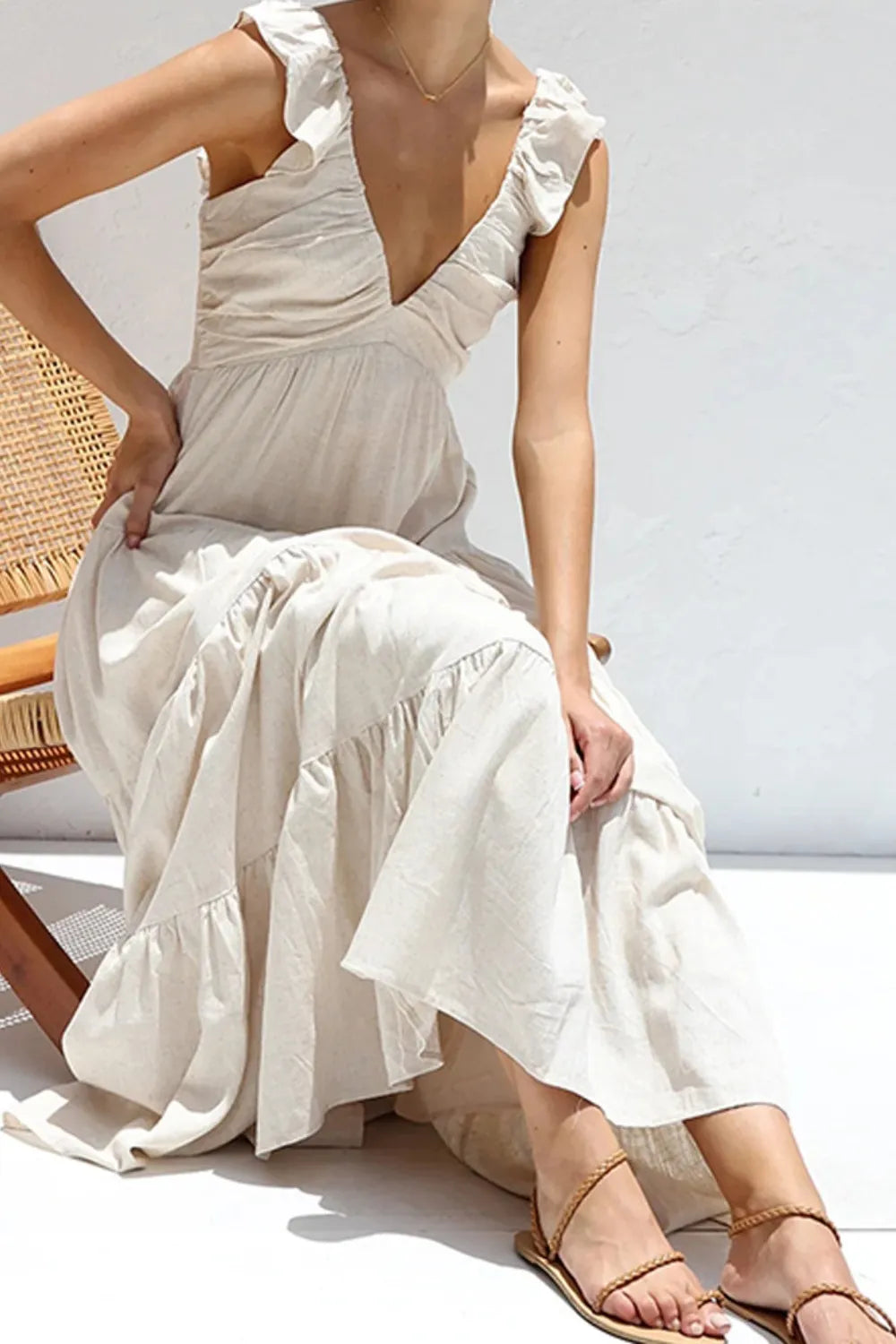 light cream ruffled v-neck tiered dress with ruffle straps and flowing tiers worn with sandals