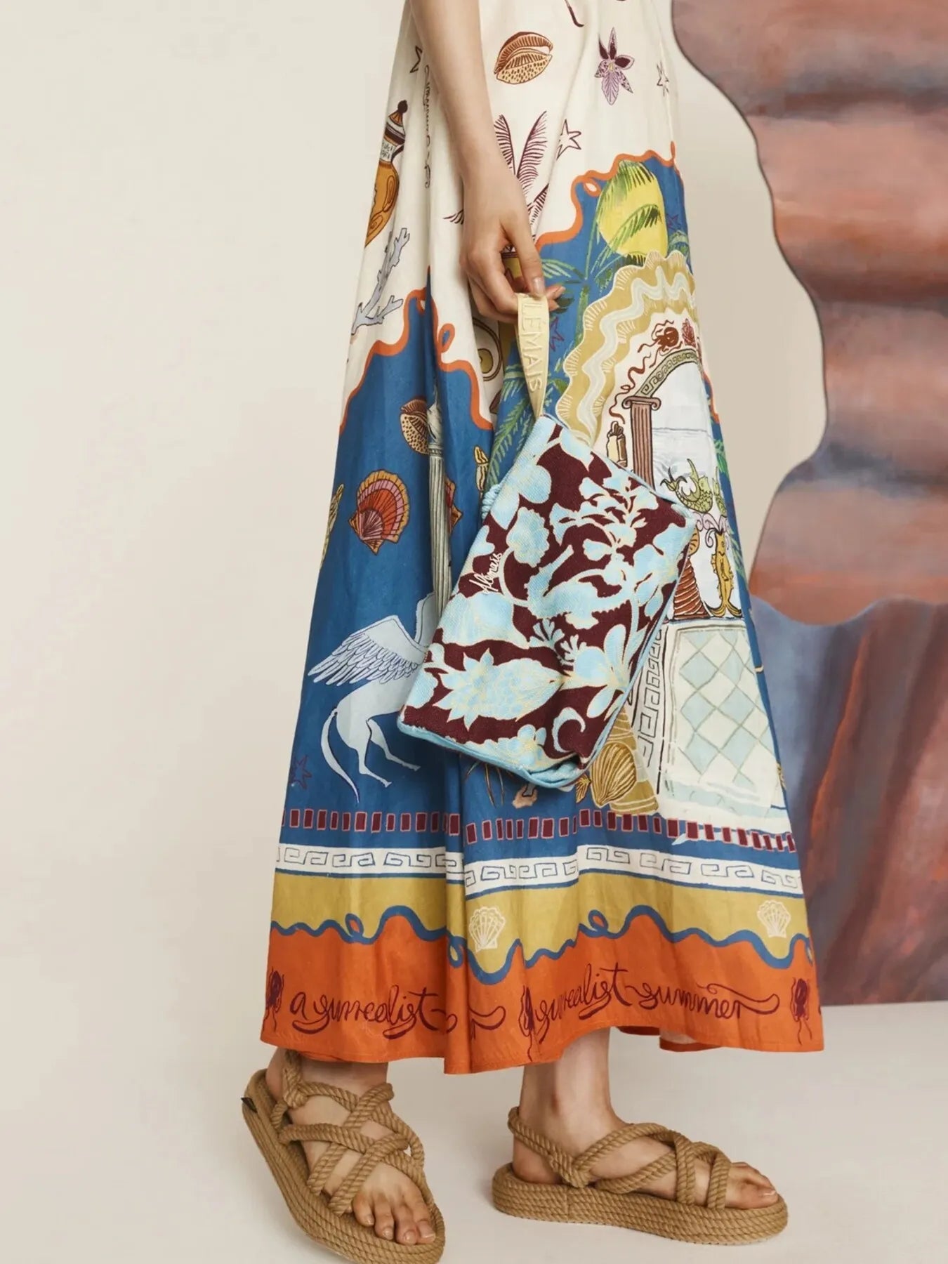 printed square neck maxi dress with colorful coastal border print paired with woven sandals and matching clutch