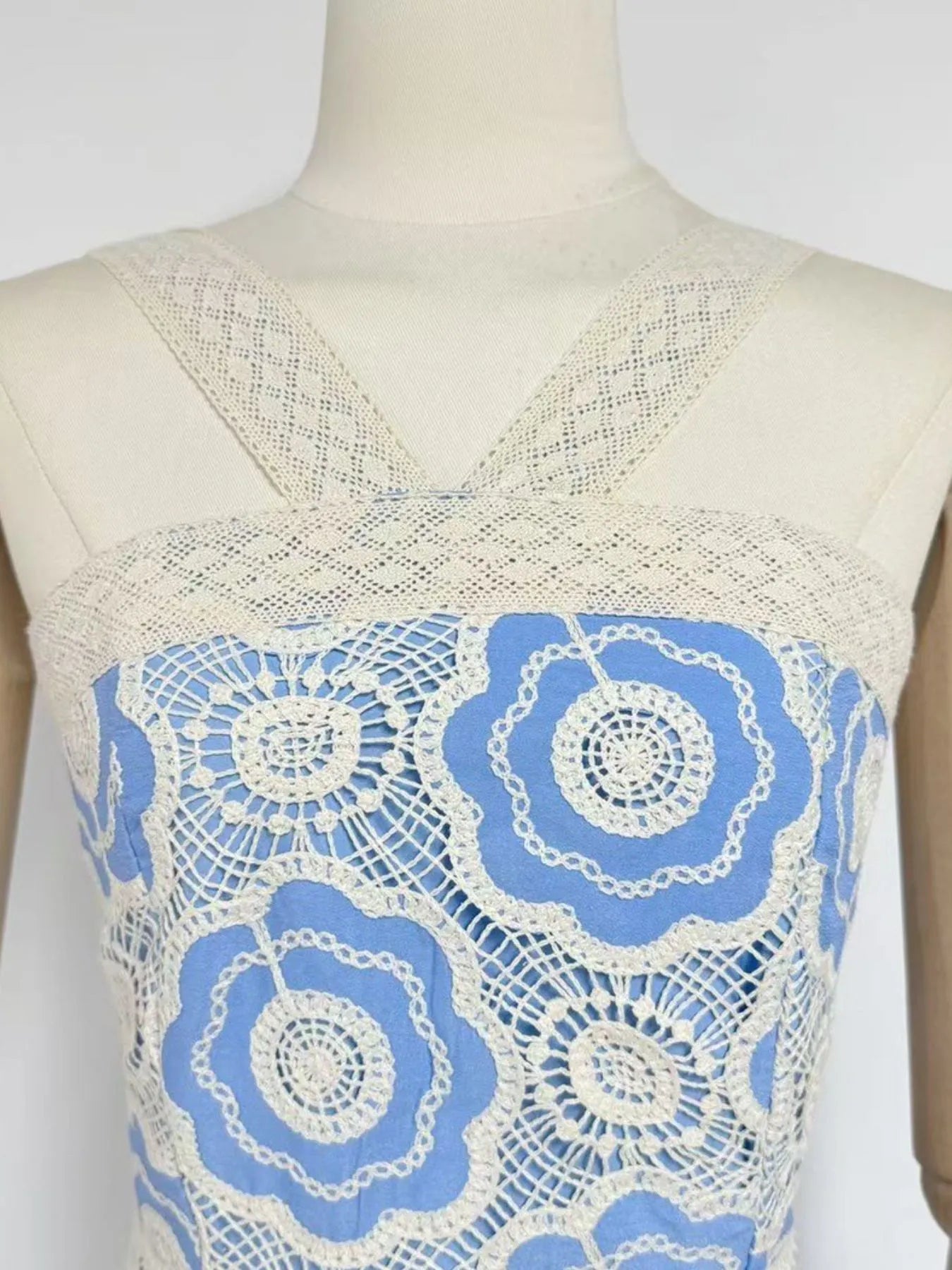 lace tiered midi dress close up of cream crochet floral bodice with blue lining and crossed straps