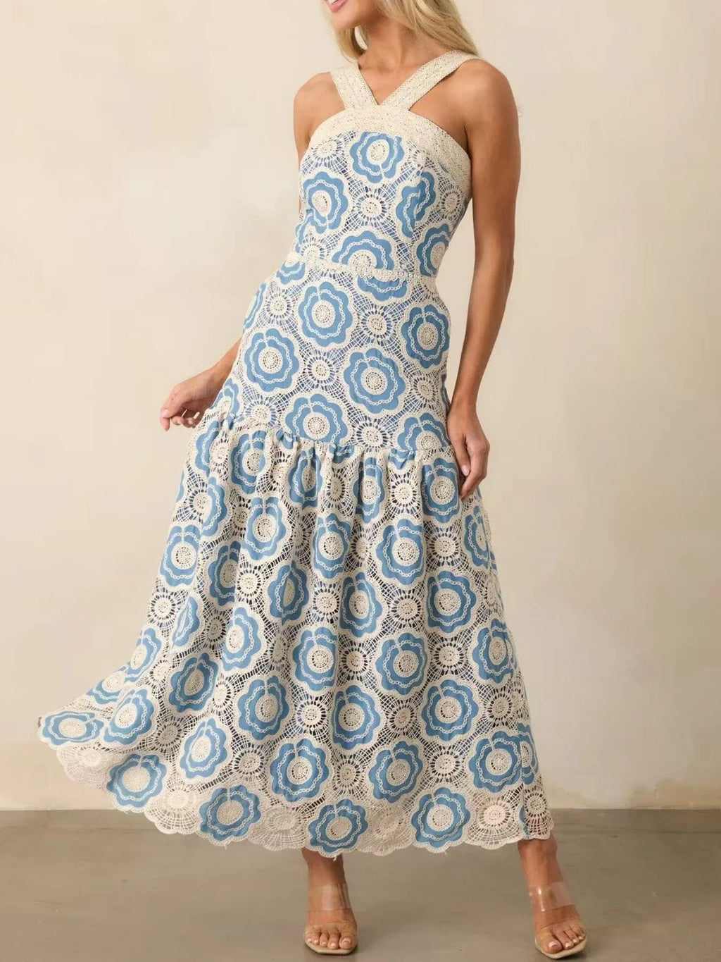 Model wearing blue and white lace tiered midi dress with crisscross straps fitted bodice and flowing ankle length tiers