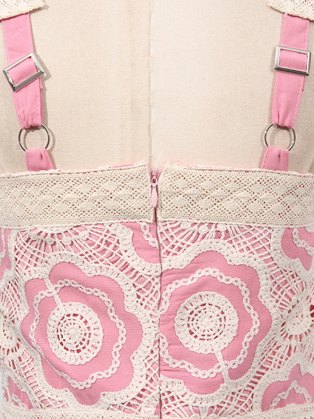 Close up back of pink and cream lace tiered midi dress showing floral lace overlay adjustable straps and center zipper