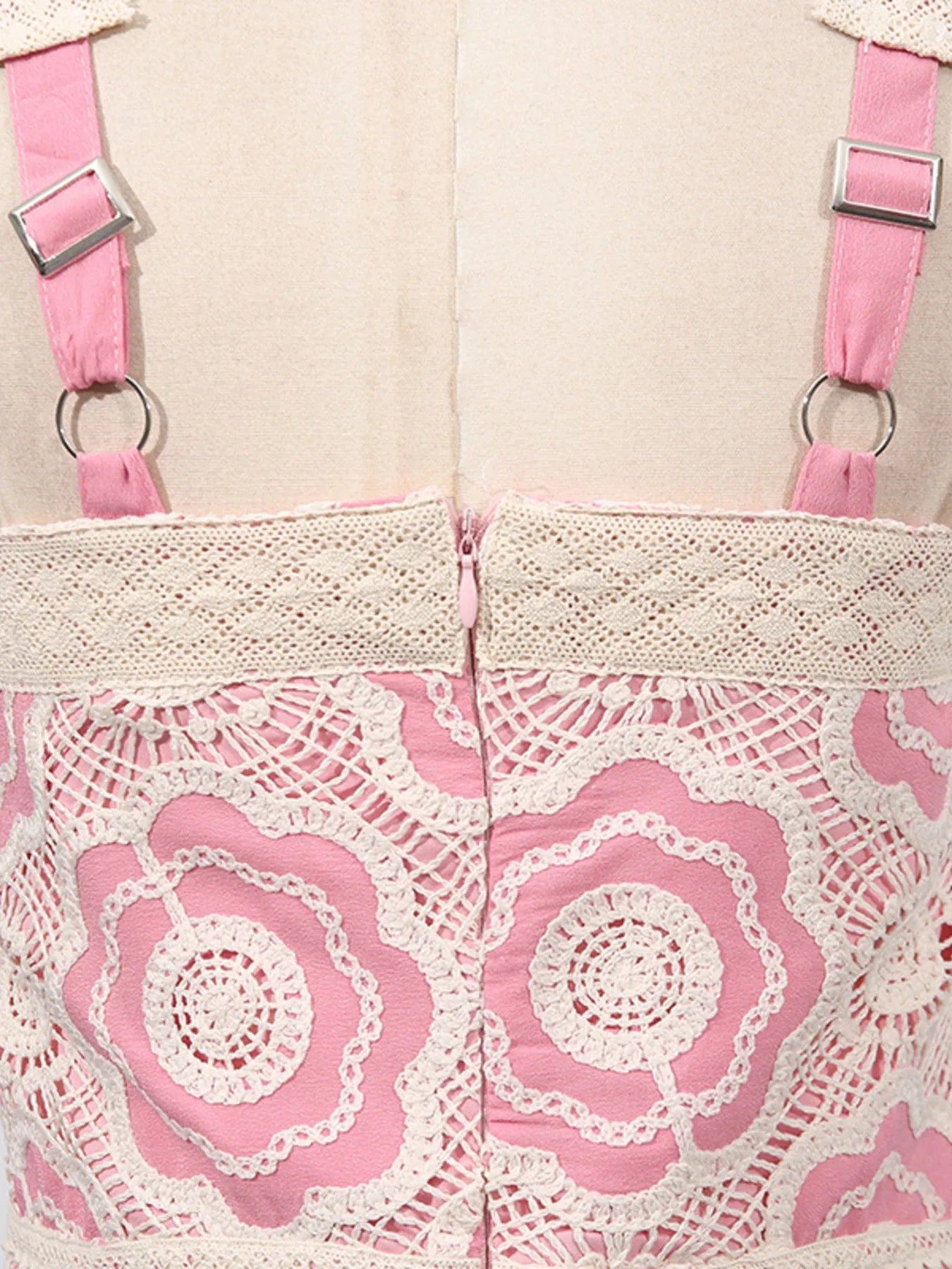 Close up back of pink and cream lace tiered midi dress showing floral lace overlay adjustable straps and center zipper