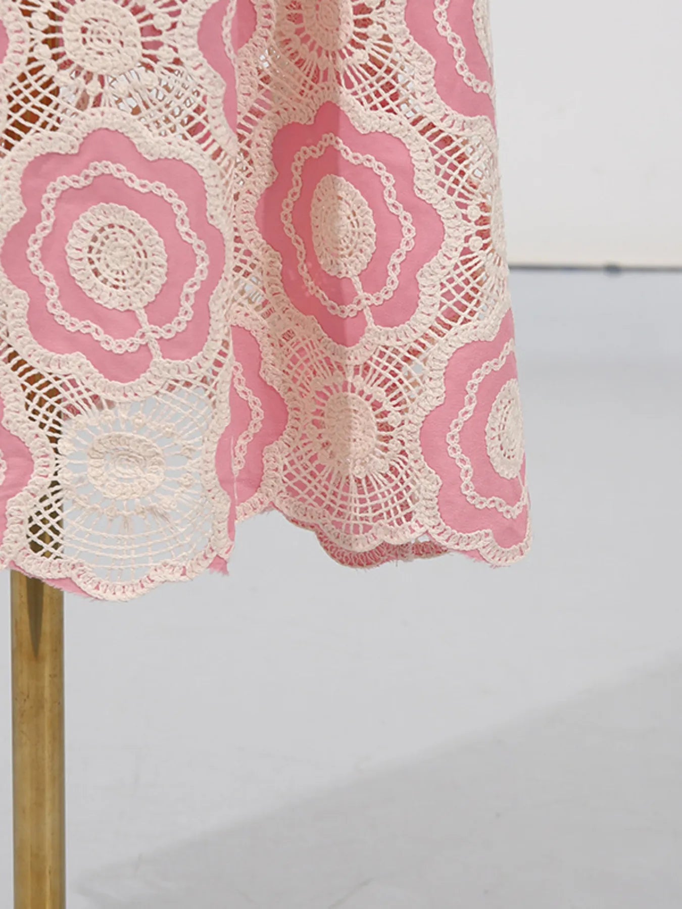 pink and cream floral crochet hem on lace tiered midi dress showing scalloped edge and gold stand