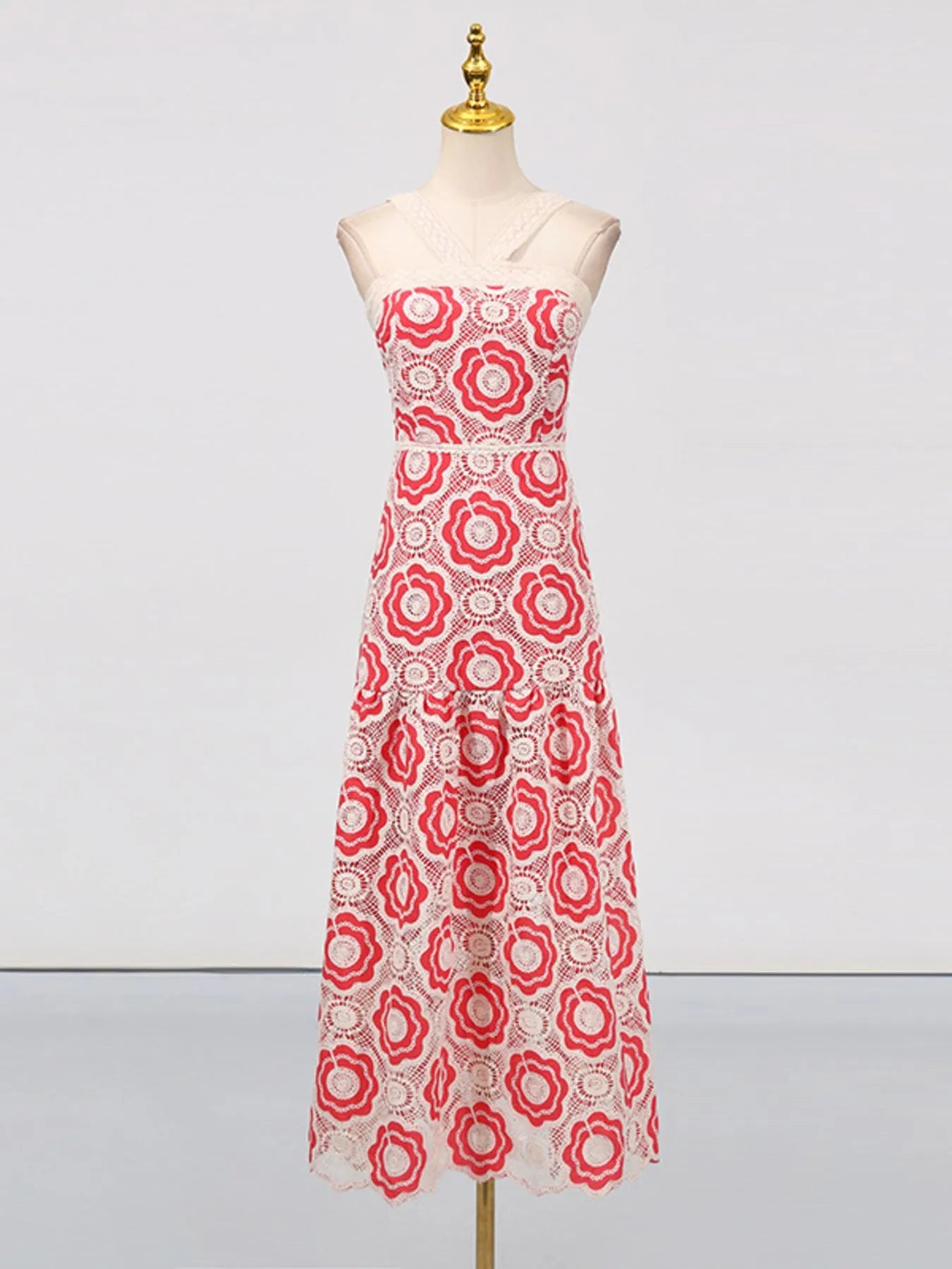 Red and white floral lace tiered midi dress on mannequin with strapless fitted bodice and scalloped hem
