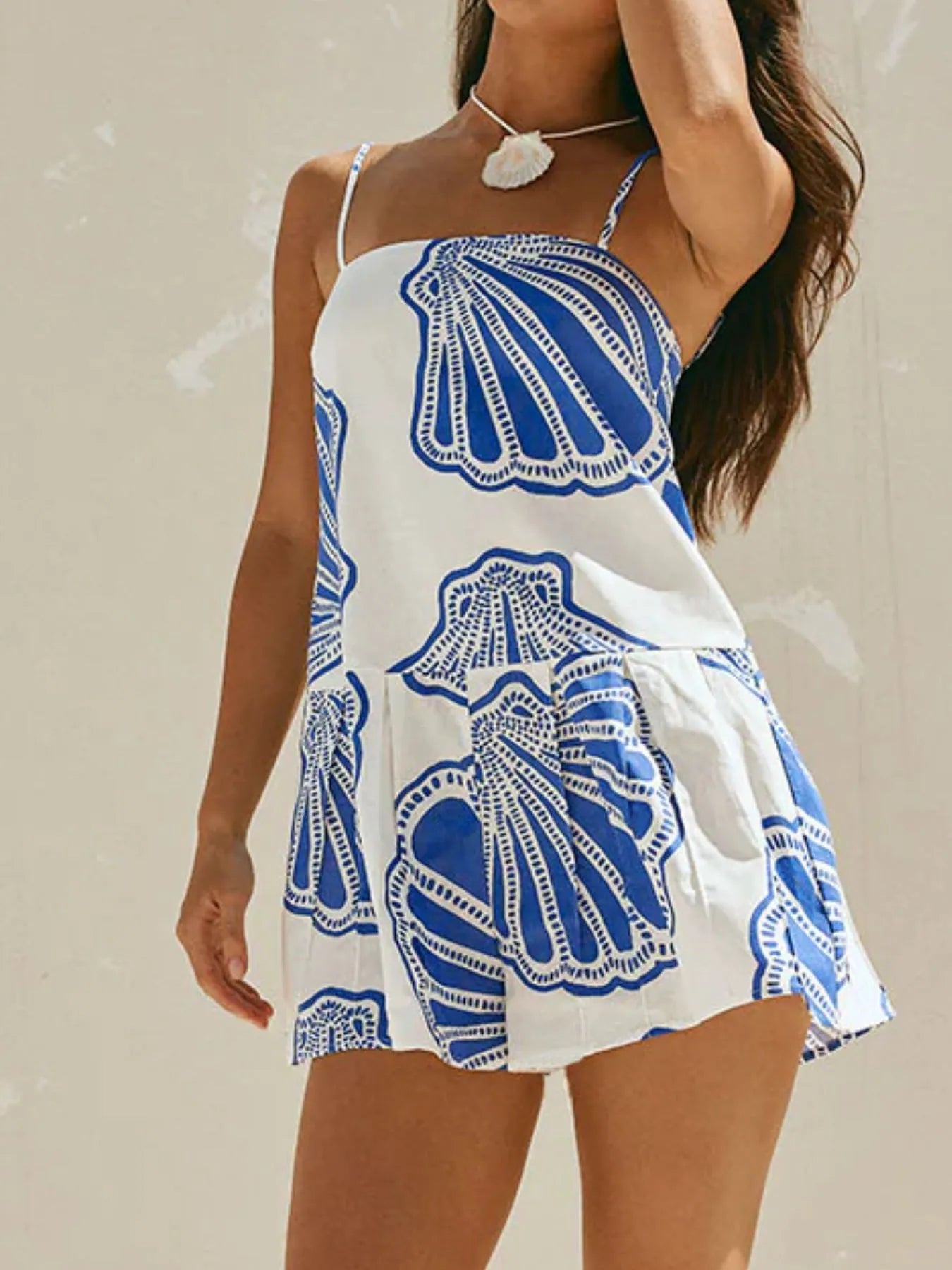 model wearing shell print summer mini dress white with bold blue shell motifs and thin straps