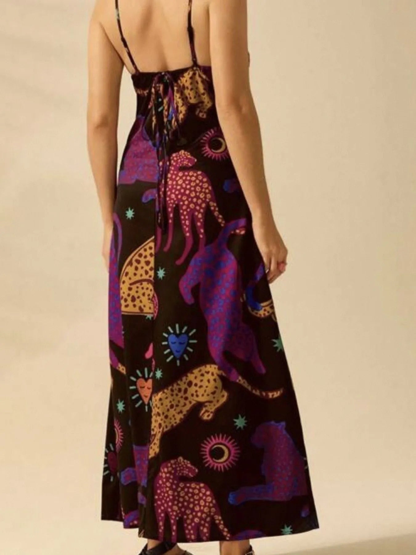 Back view of printed sleeveless maxi dress with spaghetti straps and colorful leopard and sun motifs