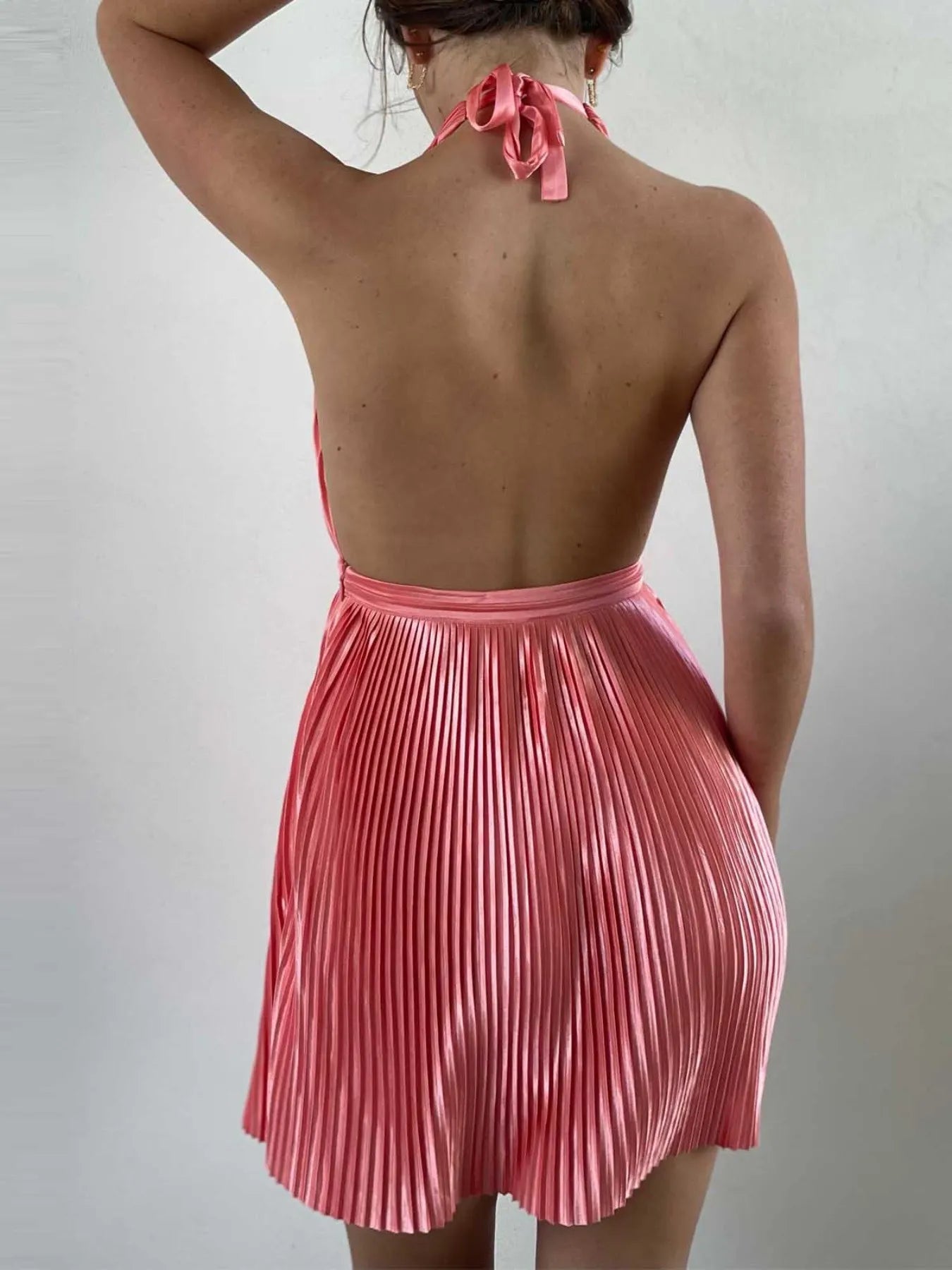 pink satin pleated halter neck mini dress back view with open low back and pleated skirt